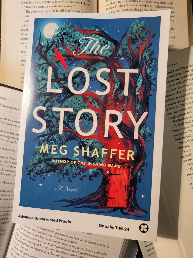 photo of The Lost Story, which rests on several other opened fantasy novels. The cover of the book depicts a tree, with a door in its trunk. A red crow flies overhead.