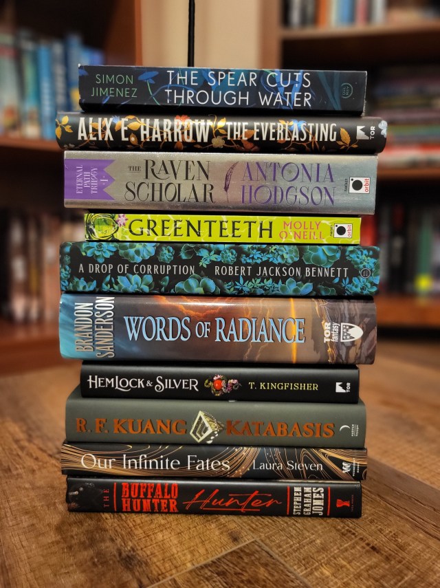 another photo of my top ten books of the year, this time as a stack in front of a couple of bookshelves